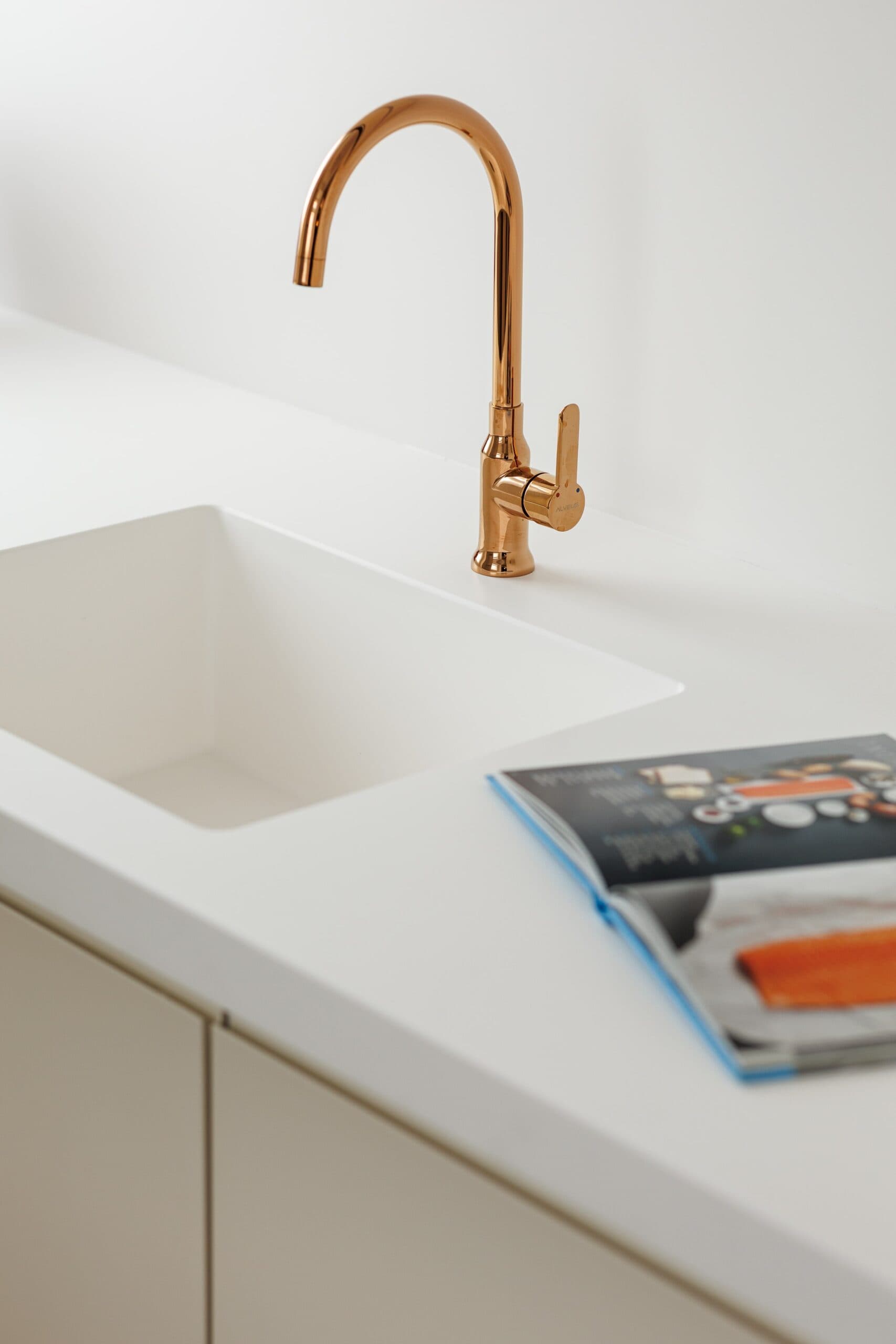 Gold faucet with white countertop